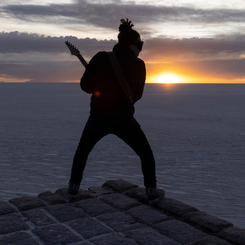 Golden hour at the Salar de Uyuni Everton Vidal Azevedo performing with a electric guitar during golden hour on the Salar de Uyuni (Sky Staircase), photo by Marvin Montes.