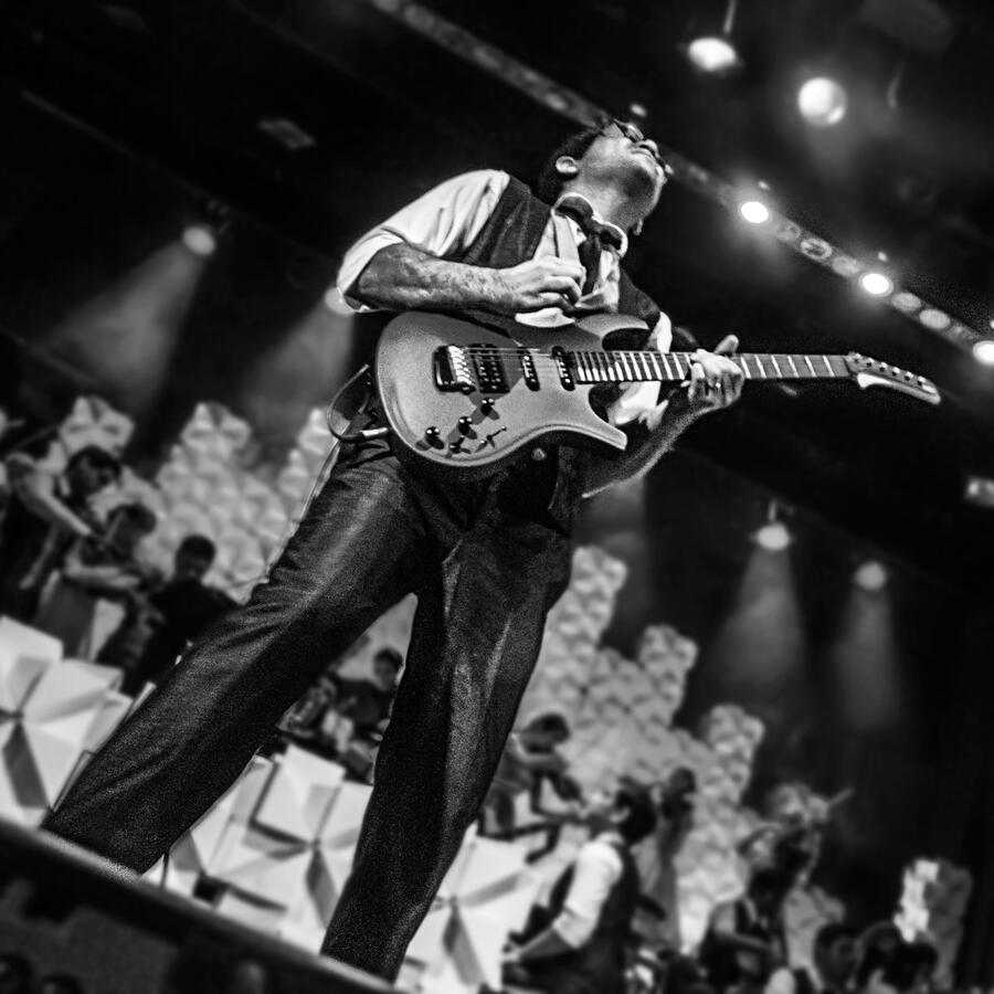 Live with the Camerata(by Antonio Dávila). Everton Vidal Azevedo performing a guitar solo with the Camerata del Oriente, Orquesta Municipal de Santa Cruz de la Sierra, black-and-white stage photo. Photo by Antonio Dávila.