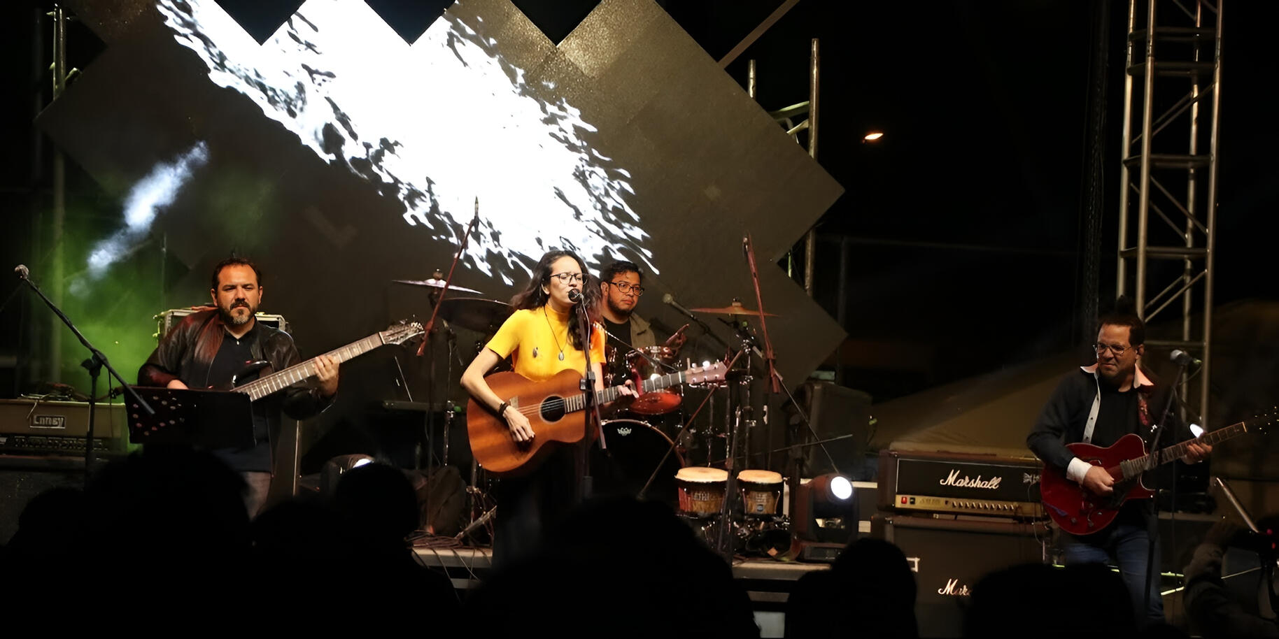 With Mila Magal at the Alternx Festival — photo by Andru Everton Vidal on stage with Mila Magal at the Alternx Festival, playing guitar under colorful lights, captured by photographer Andru